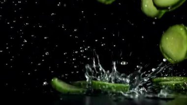 Dilimlenmiş salatalıklar masaya düşer. 1000 fps 'de yüksek hızlı bir kamerayla çekildi. Yüksek kaliteli FullHD görüntüler