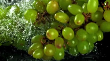 Yeşil üzümler suya düşer. 1000 fps 'de yüksek hızlı bir kamerayla çekildi. Yüksek kaliteli FullHD görüntüler