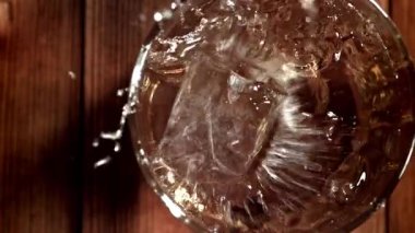 Buz bir bardak viskinin içine düşer. 1000 fps 'de yüksek hızlı bir kamerayla çekildi. Yüksek kaliteli FullHD görüntüler