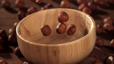 Fındıklar ahşap bir kaseye düşer. 1000 fps 'de yüksek hızlı bir kamerayla çekildi. Yüksek kaliteli FullHD görüntüler