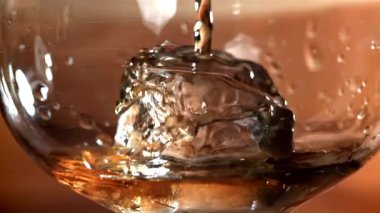 Viski buzlu bir bardağa dökülür. 1000 fps 'de yüksek hızlı bir kamerayla çekildi. Yüksek kaliteli FullHD görüntüler