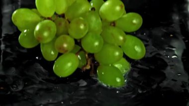 Yeşil üzümler suya düşer. 1000 fps 'de yüksek hızlı bir kamerayla çekildi. Yüksek kaliteli FullHD görüntüler