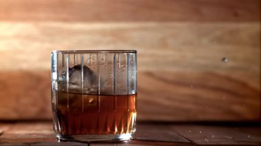 Buz bir bardak viskinin içine düşer. 1000 fps 'de yüksek hızlı bir kamerayla çekildi. Yüksek kaliteli FullHD görüntüler