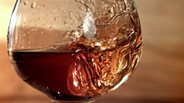 Buz bir bardak viskinin içine düşer. 1000 fps 'de yüksek hızlı bir kamerayla çekildi. Yüksek kaliteli FullHD görüntüler