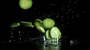 Dilimlenmiş salatalıklar masaya düşer. 1000 fps 'de yüksek hızlı bir kamerayla çekildi. Yüksek kaliteli FullHD görüntüler