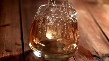 Buz bir bardak viskinin içine düşer. 1000 fps 'de yüksek hızlı bir kamerayla çekildi. Yüksek kaliteli FullHD görüntüler