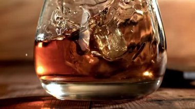 Buz bir bardak viskinin içine düşer. 1000 fps 'de yüksek hızlı bir kamerayla çekildi. Yüksek kaliteli FullHD görüntüler