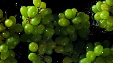 Yeşil üzümler suya düşer. 1000 fps 'de yüksek hızlı bir kamerayla çekildi. Yüksek kaliteli FullHD görüntüler