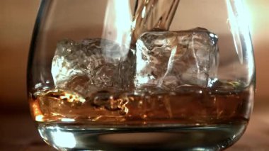 Viski buzlu bir bardağa dökülür. 1000 fps 'de yüksek hızlı bir kamerayla çekildi. Yüksek kaliteli FullHD görüntüler