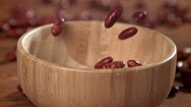 Kırmızı fasulyeler ahşap bir kaba düşer. 1000 fps 'de yüksek hızlı bir kamerayla çekildi. Yüksek kaliteli FullHD görüntüler