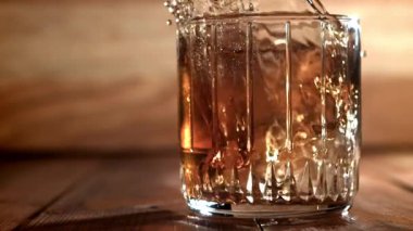 Buz bir bardak viskinin içine düşer. 1000 fps 'de yüksek hızlı bir kamerayla çekildi. Yüksek kaliteli FullHD görüntüler
