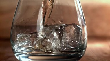 Viski buzlu bir bardağa dökülür. 1000 fps 'de yüksek hızlı bir kamerayla çekildi. Yüksek kaliteli FullHD görüntüler