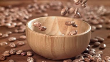 Beyaz fasulyeler ahşap bir kaba düşer. 1000 fps 'de yüksek hızlı bir kamerayla çekildi. Yüksek kaliteli FullHD görüntüler