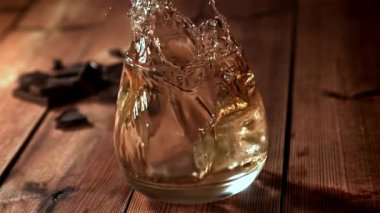 Buz bir bardak viskinin içine düşer. 1000 fps 'de yüksek hızlı bir kamerayla çekildi. Yüksek kaliteli FullHD görüntüler