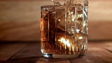 Buz bir bardak viskinin içine düşer. 1000 fps 'de yüksek hızlı bir kamerayla çekildi. Yüksek kaliteli FullHD görüntüler