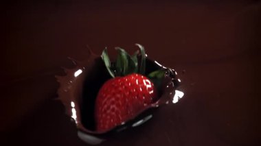 Çilekler çikolatanın içine düşer. 1000 fps 'de yüksek hızlı bir kamerayla çekildi. Yüksek kaliteli FullHD görüntüler