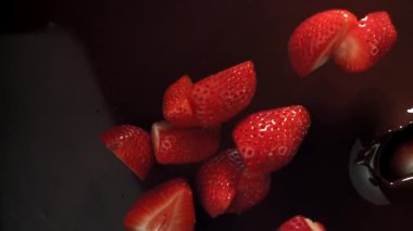 Çilekler çikolatanın içine düşer. 1000 fps 'de yüksek hızlı bir kamerayla çekildi. Yüksek kaliteli FullHD görüntüler