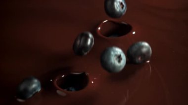 Yaban mersini çikolatanın içine düşer. 1000 fps 'de yüksek hızlı bir kamerayla çekildi. Yüksek kaliteli FullHD görüntüler