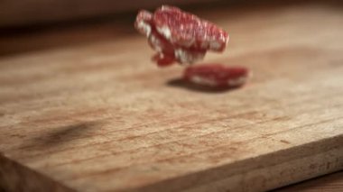 Dilimlenmiş salam masaya düştü. 1000 fps 'de yüksek hızlı bir kamerayla çekildi. Yüksek kaliteli FullHD görüntüler