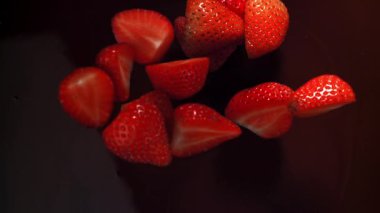 Çilekler çikolatanın içine düşer. 1000 fps 'de yüksek hızlı bir kamerayla çekildi. Yüksek kaliteli FullHD görüntüler
