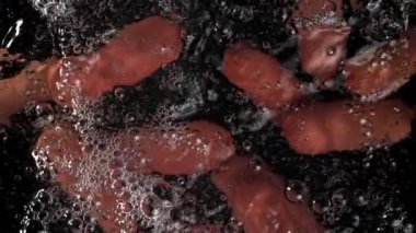 Sosisler suda yüzer. 1000 fps 'de yüksek hızlı bir kamerayla çekildi. Yüksek kaliteli FullHD görüntüler