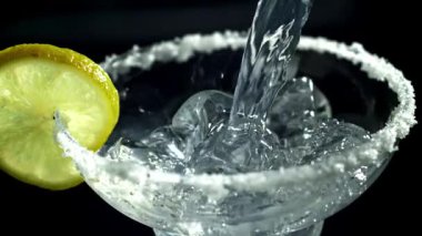 Bir margarita kokteyli bardağa dökülür. 1000 fps 'de yüksek hızlı bir kamerayla çekildi. Yüksek kaliteli FullHD görüntüler