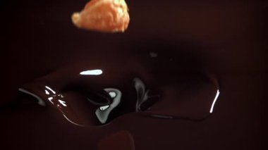 Mandalina dilimleri çikolatanın içine düşer. 1000 fps 'de yüksek hızlı bir kamerayla çekildi. Yüksek kaliteli FullHD görüntüler