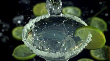 Buzlar margarita kokteylinin içine düşer. 1000 fps 'de yüksek hızlı bir kamerayla çekildi. Yüksek kaliteli FullHD görüntüler