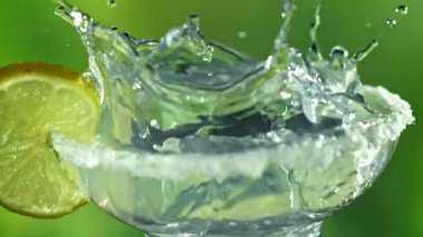 Buzlar margarita kokteylinin içine düşer. 1000 fps 'de yüksek hızlı bir kamerayla çekildi. Yüksek kaliteli FullHD görüntüler