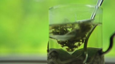 Hareket halindeki bir trende, masanın üzerindeki bardakta yeşil çay. Yüksek kalite 4k görüntü