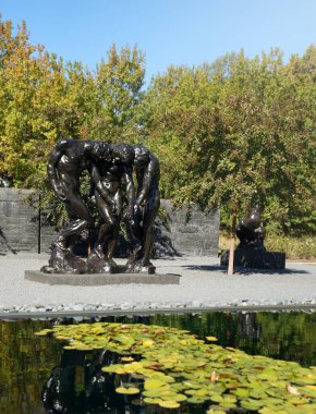 Raleigh, NC - USA - 10-14-2022: The sculpture garden at the North Carolina Museum of Art in Raleigh, featuring The Three Shades by Rodin clipart