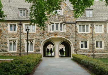 Durham NC 'deki Duke Üniversitesi kampüsünde öğrenciler gotik kemerlerin altında yürüyor                               