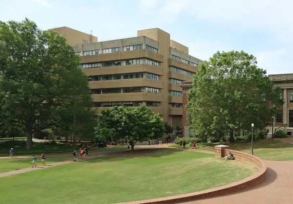 Raleigh, NC - ABD - 4-25-2019: Öğrenciler NC Eyalet Üniversitesi kampüsündeki Poe Hall yakınlarında yürüyorlar. Binada kanserle bağlantılı zararlı PCB kimyasalları bulunduğundan şüpheleniliyor