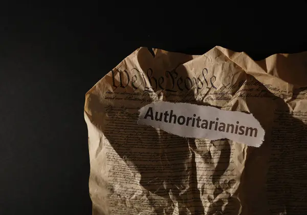 stock image Crumpled and torn US Constitution with Authoritarianism newspaper headline                               