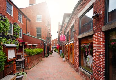 Portsmouth, NH - ABD - 08-08-2024: Portsmouth 'un tarihi şehir merkezindeki sakin bir yaya sokağı boyunca perakende mağazaları ve restoranlar