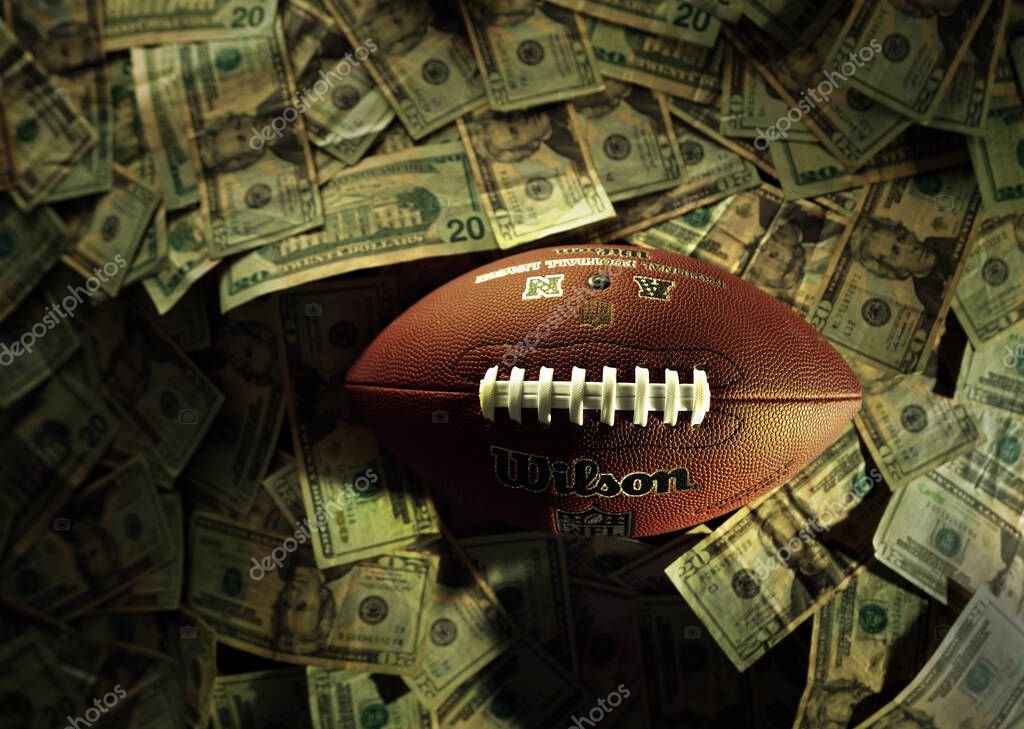 Detroit, MI - USA - 10-21-2024: A Wilson NFL football from above on a pile of money