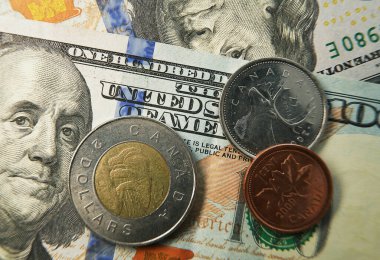 100 dolarlık banknotun Kanada sikkelerine yakın çekim                               