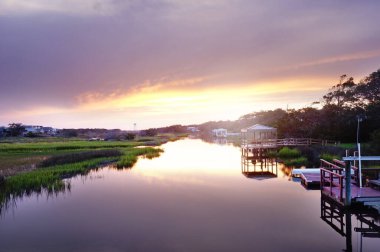 Waterfront houses along the marsh in Oak Island NC at sunset  clipart