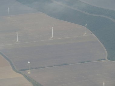 Kesilmiş tarlalar ve rüzgar türbinleriyle kırsal alan manzarası