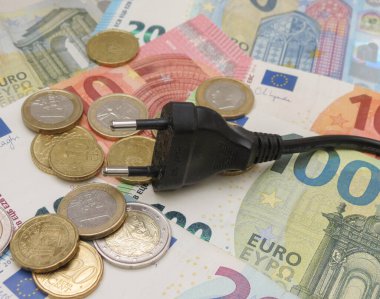 electric plug over EUR notes and coins useful as energy cost concept