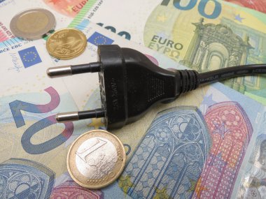 electric plug over EUR notes and coins useful as energy cost concept