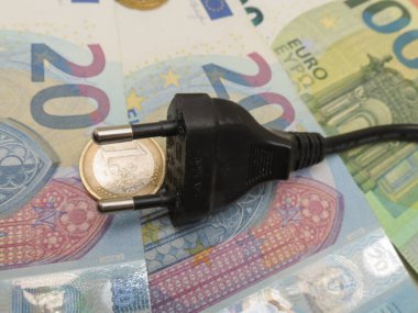 BRUESSEL, BELGIUM - CIRCA FEBRUARY 2023: electric plug over EUR notes and coins useful as energy cost concept