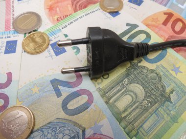 BRUESSEL, BELGIUM - CIRCA FEBRUARY 2023: electric plug over EUR notes and coins useful as energy cost concept