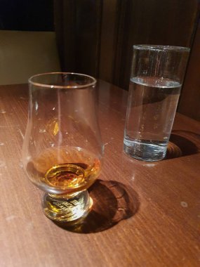EDINBURGH, İngiltere - CIRCA FEBRUARY 2023: Masada bir bardak viski ve bir bardak su