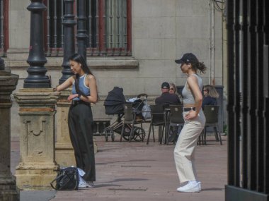 Oviedo, İspanya - CIRCA MARCH 2023: İki kız ana meydanda dans ediyor ve bir video kaydediyor