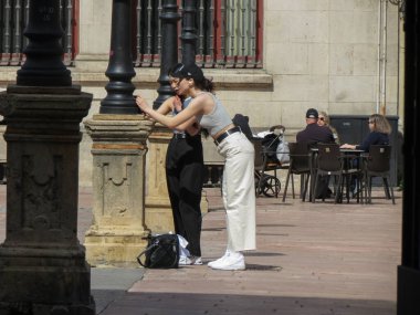 Oviedo, İspanya - 31 Mart 2023: İki kız ana meydanda dans ediyor ve bir video kaydediyor