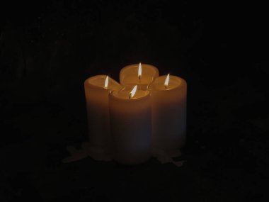 Gecenin karanlığında dört mum yanıyor.