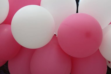 Beyaz ve pembe şişirilebilir hava balonları gaz veya hava ile dolu.