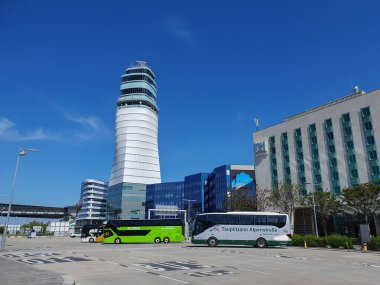 VIENNA, AUSTRIA - APRIL 13, 2024: Schwechat airport control tower and bus parking clipart