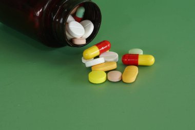 Yeşil arka planda konteynır ile haplar